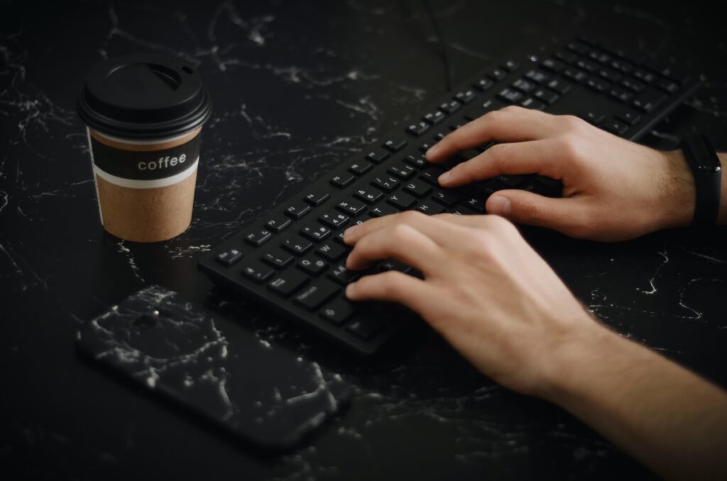 Hands typing on a black keyboard